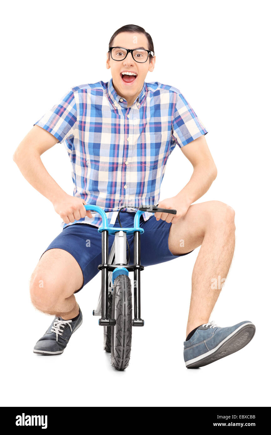 Silly young man riding a small childish bike isolated on white background Stock Photo