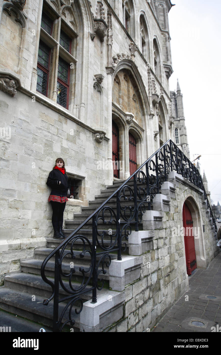 young woman standing on stairs of cloth hall, Belgium, Oost-Vlaanderen, Gent Stock Photo