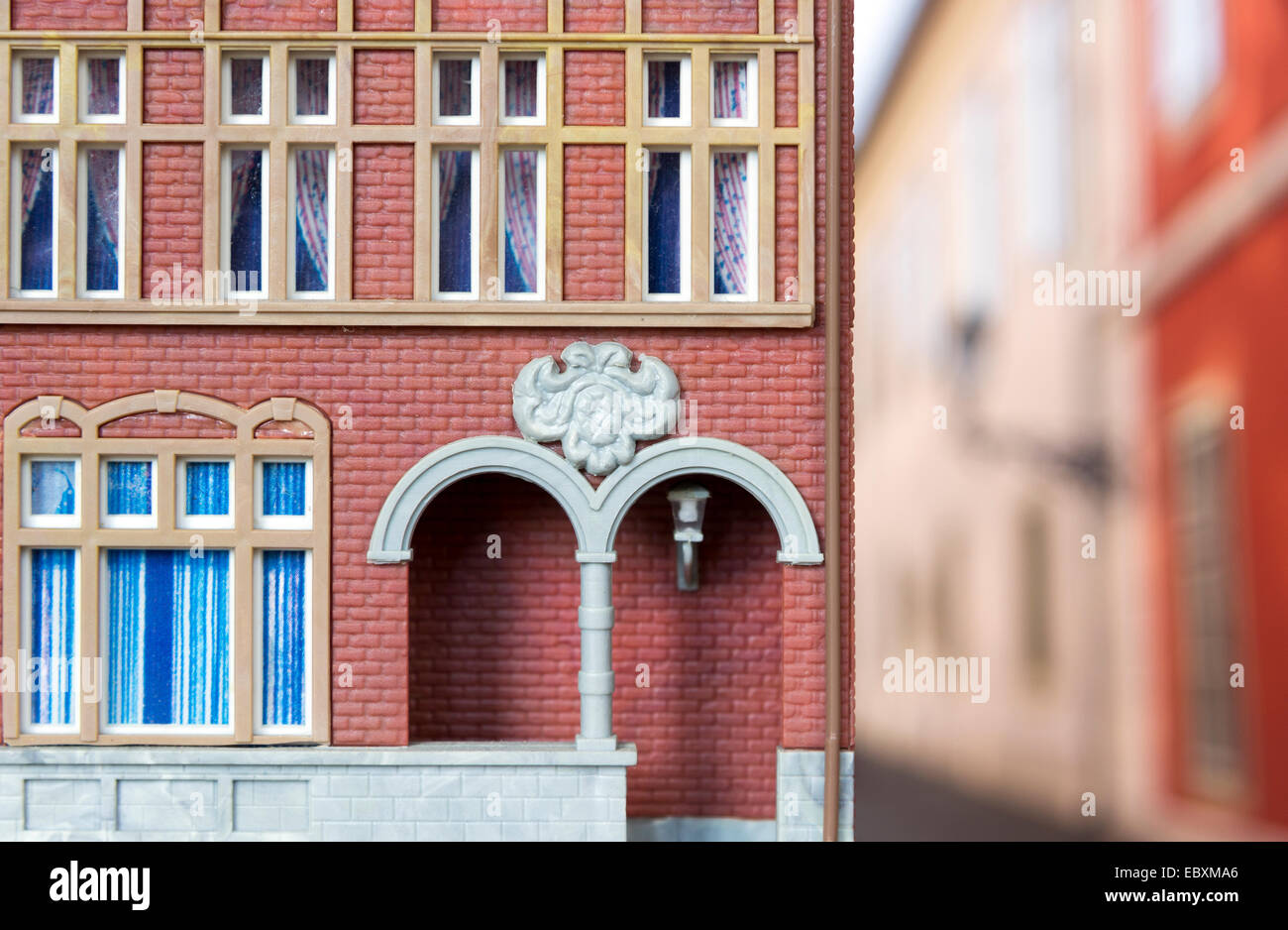 Close up of a model railway building, against a photograph of a street, still life Stock Photo