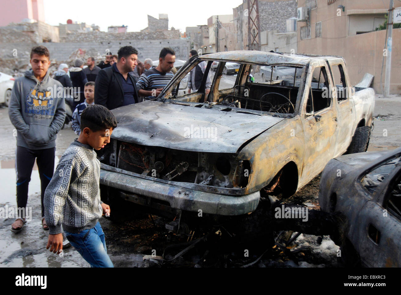 Kirkuk, Iraq. 5th Dec, 2014. A damaged car is seen at an explosion site in the city of Kirkuk, Iraq, Dec 5, 2014. A suicide bomber with an explosive vest blew himself up in a cafe in the northern Iraqi city of Kirkuk, killing at least 15 people and wounding 20 others on Dec. 4, a local police told Xinhua on condition of anonymity. © Dena Assad/Xinhua/Alamy Live News Stock Photo