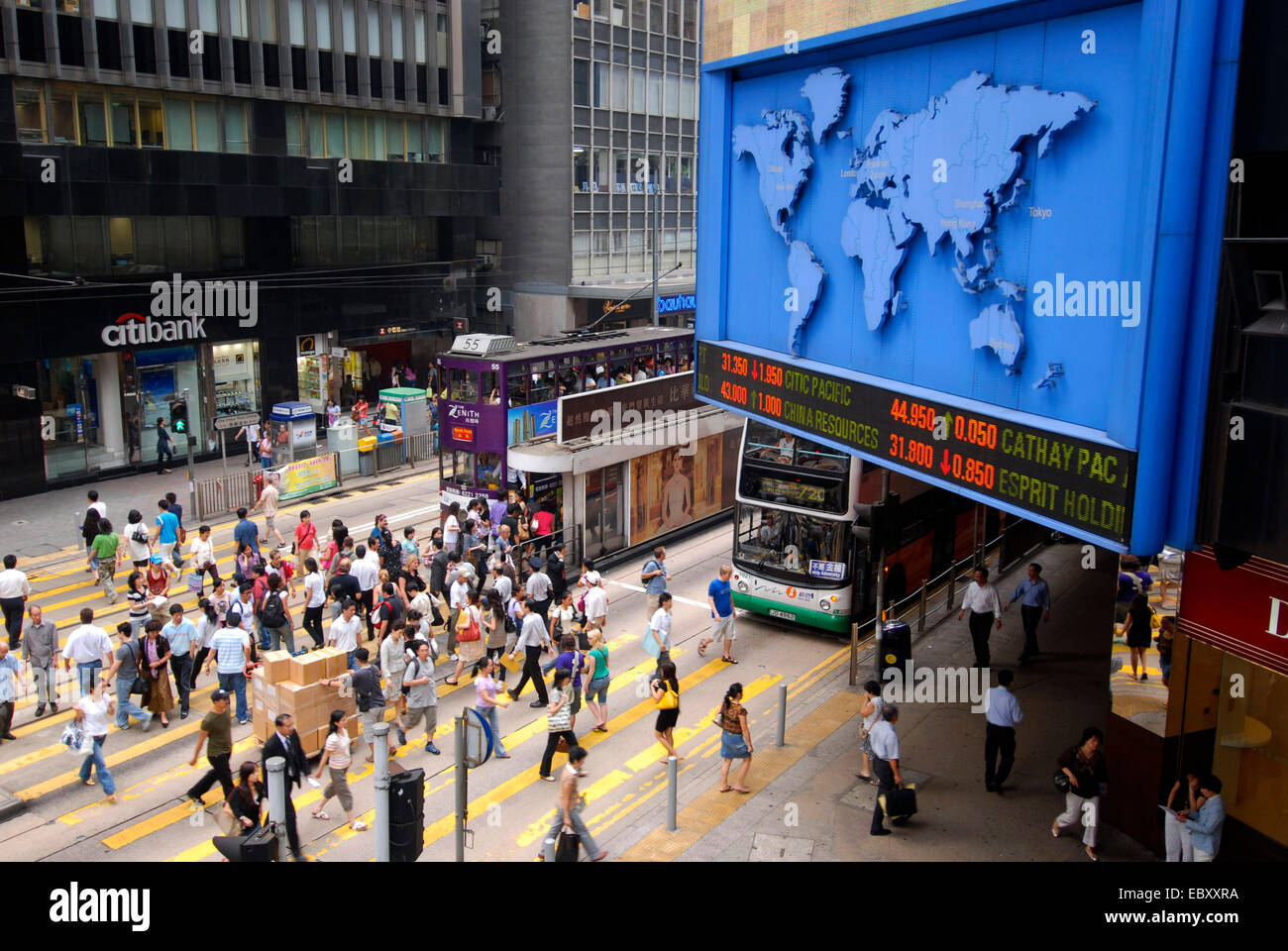 people in downtown, display panel with world map and stock list, China, Hong Kong Stock Photo