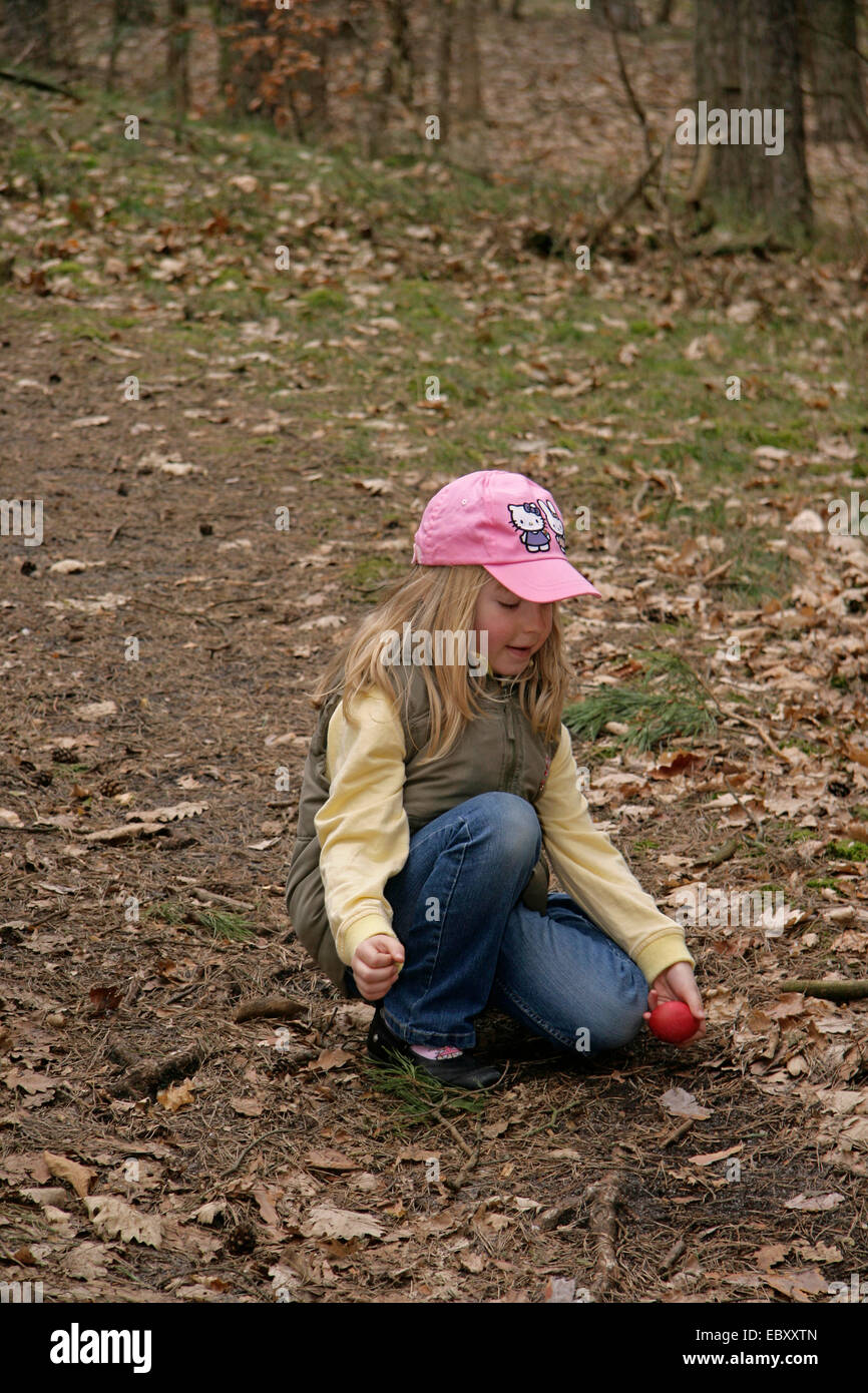 little girl rolling downhill an Easter egg, Germany Stock Photo