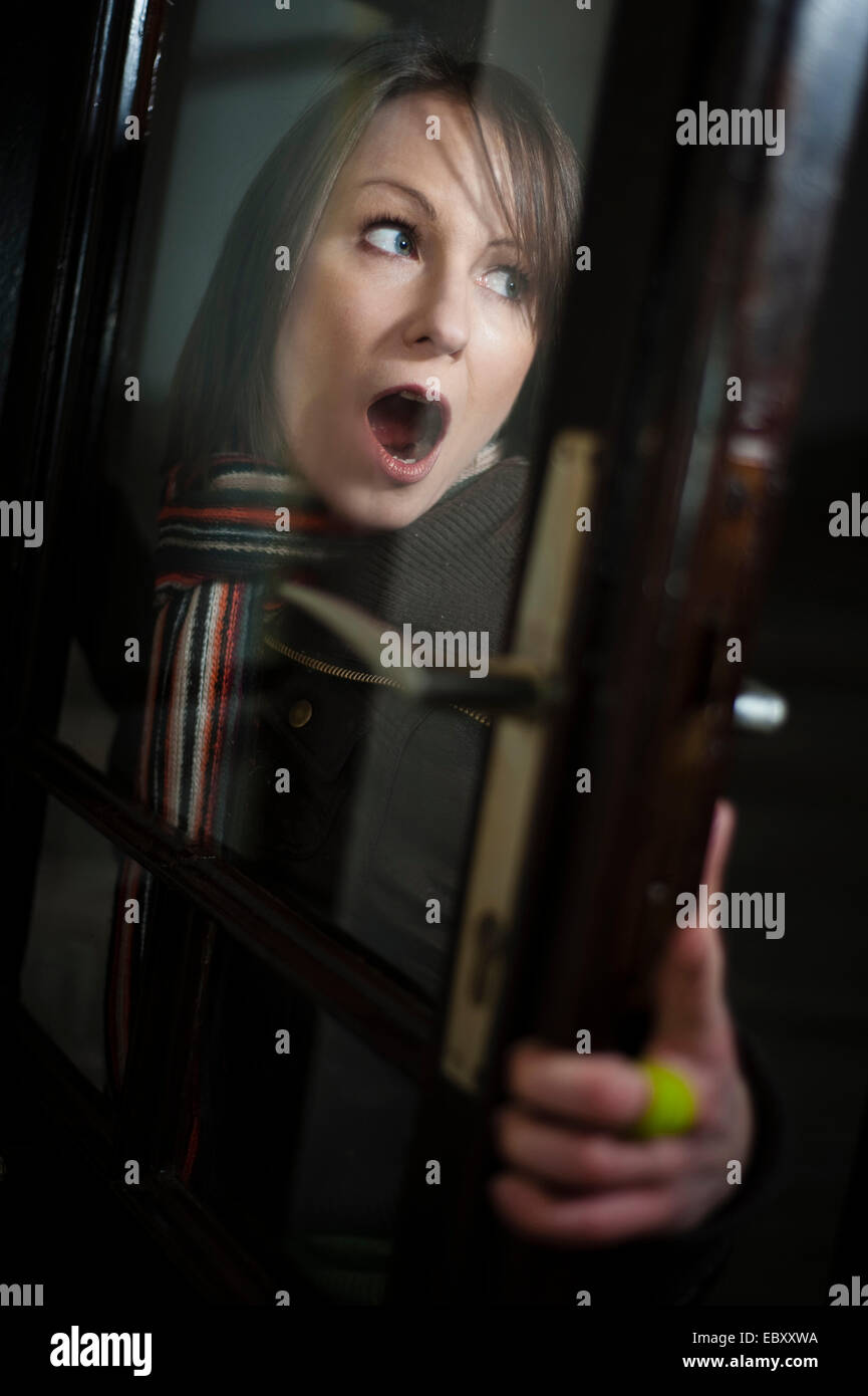 woman in panic at a door Stock Photo