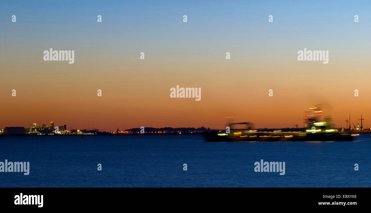 ship on the Dollart after sunset with the city Delfzijl in the background, Germany, Lower Saxony, East Frisia Stock Photo