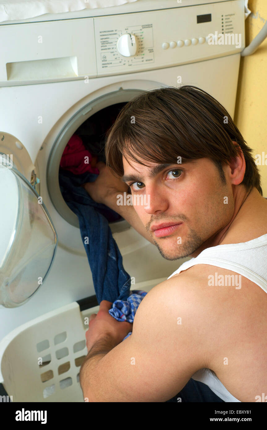 man using a washing machine Stock Photo