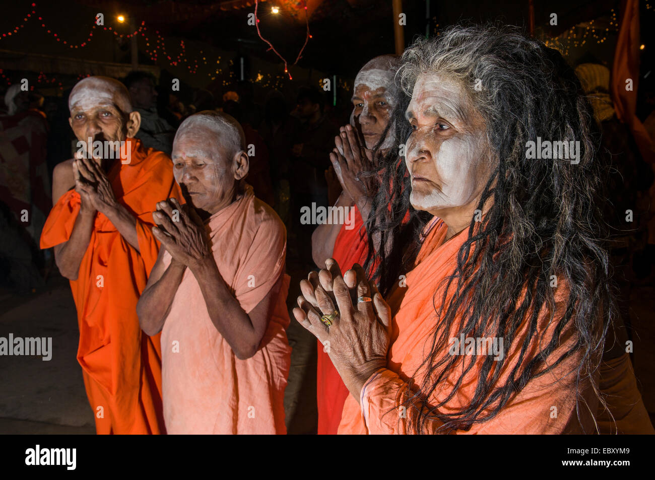Group of newly initiated Shiva sadhvis, holy women, from Avan Akhara, praying at night at the Sangam, the confluence of the Stock Photo