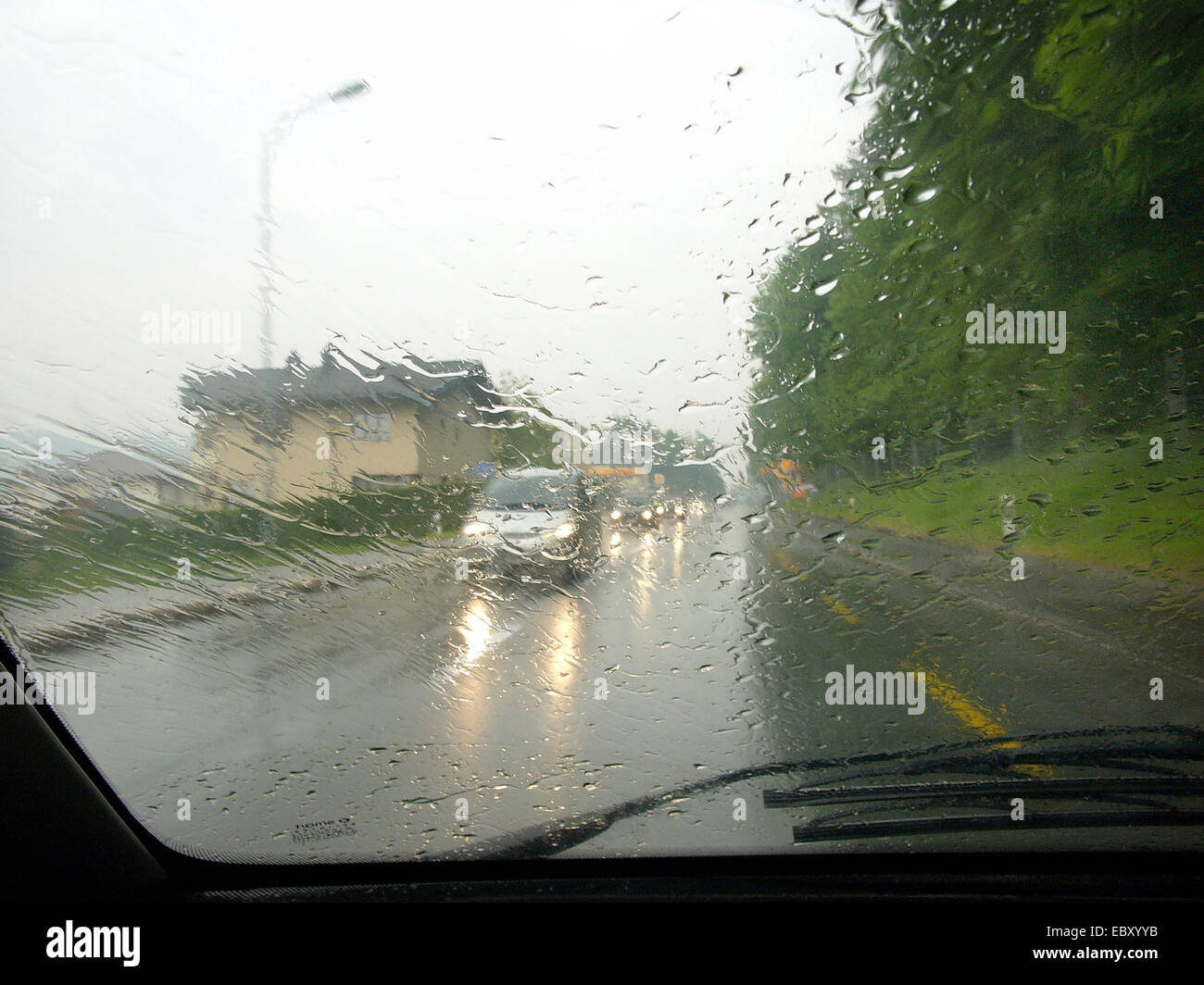 car with lights on, poor sight because of rain Stock Photo Alamy