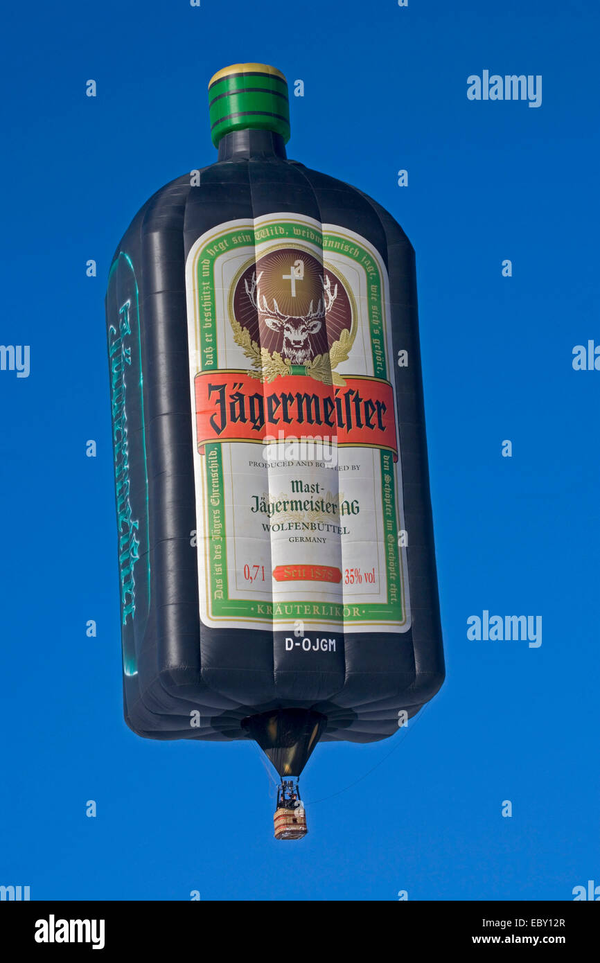 hot-air balloon in the shape of a Jaegermeister bottle flying in front of a blue sky, Germany, Bavaria, Allgaeu, Oberstdorf Stock Photo