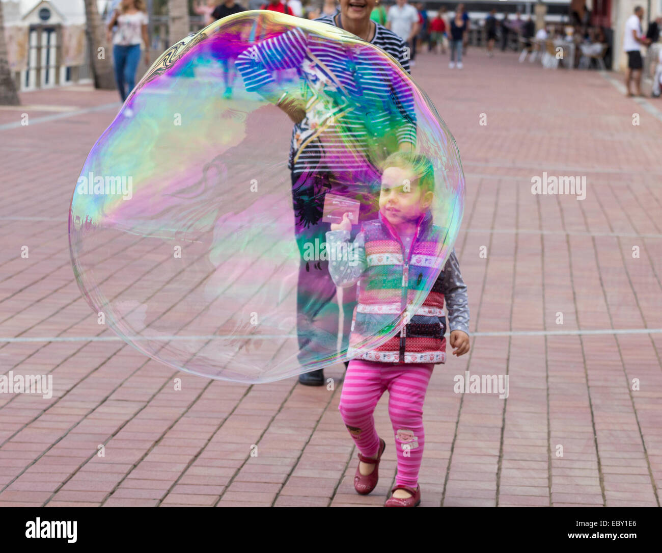 Las Palmas, Gran Canaria, Canary Islands, Spain. 5th December, 2014. Young girl about to burst giant bubble made by street entertainer in Las Palmas, Gran Canaria Credit:  ALANDAWSONPHOTOGRAPHY/Alamy Live News Stock Photo