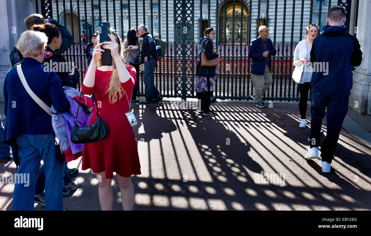 Members of the public outside Buckingham palace taking photographs and selfies Stock Photo