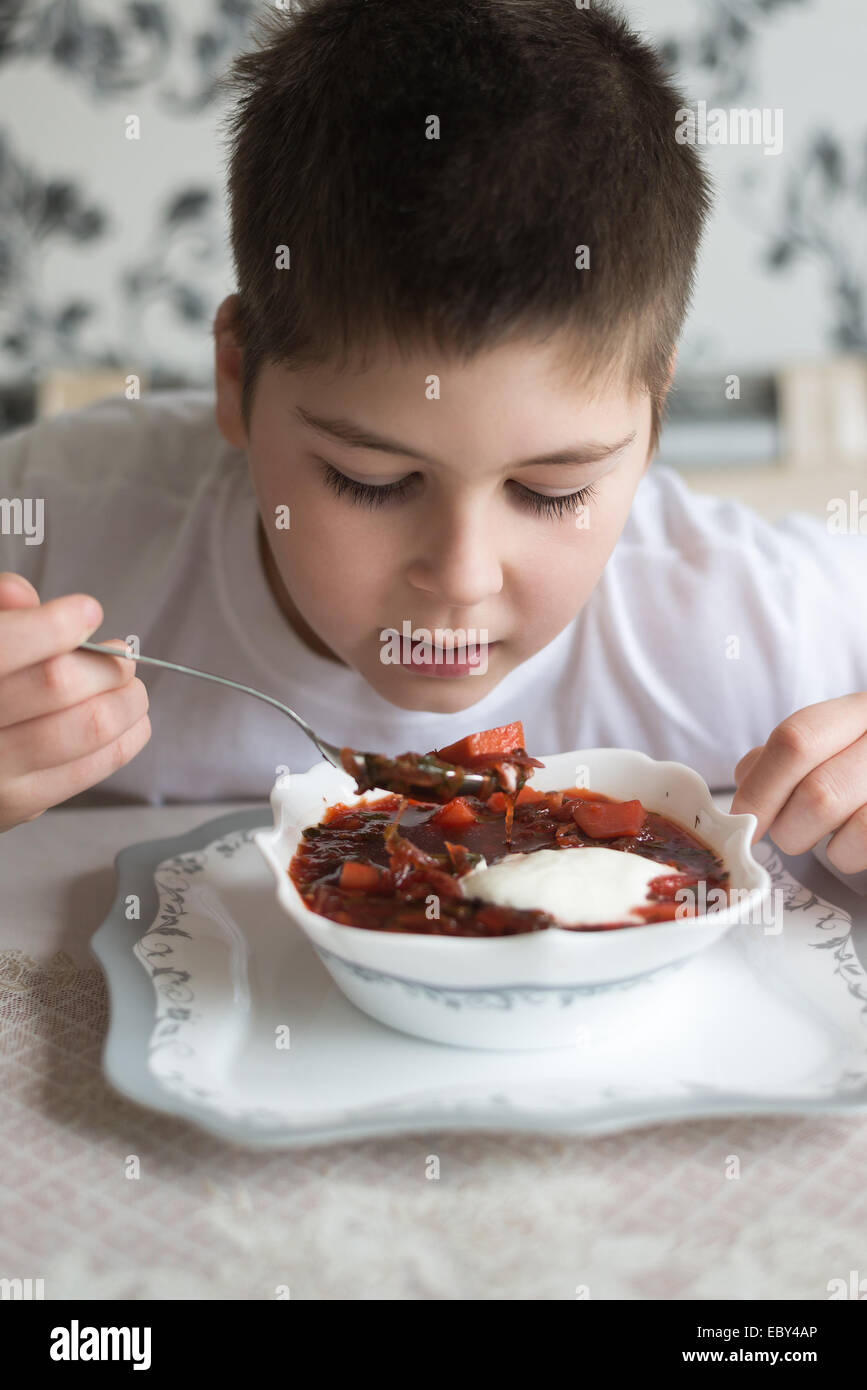 Boy teenager eating soup at kitchen table Stock Photo Alamy