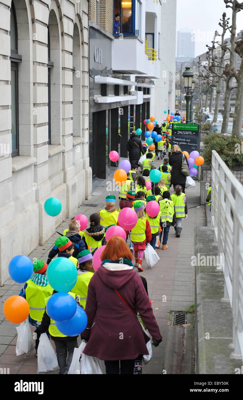 Brussels. 5th Dec, 2014. Children taking gifts and balloons given by Saint-Nicolas (Sinterklaas) go back to school in Brussels of Belgium, Dec. 5, 2014. Saint-Nicolas, who is one of the sources of the popular Christmas icon of Santa Claus, is celebrated annually with the giving of gifts on the night before or on the Saint Nicholas Day itself on Dec. 6 in Belgium. © Ye Pingfan/Xinhua/Alamy Live News Stock Photo