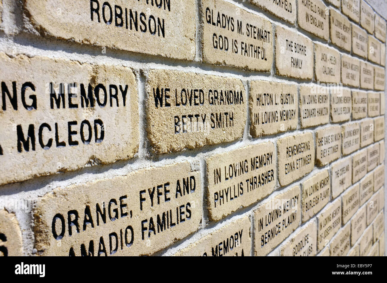 A brick wall with words carved into it. Stock Photo