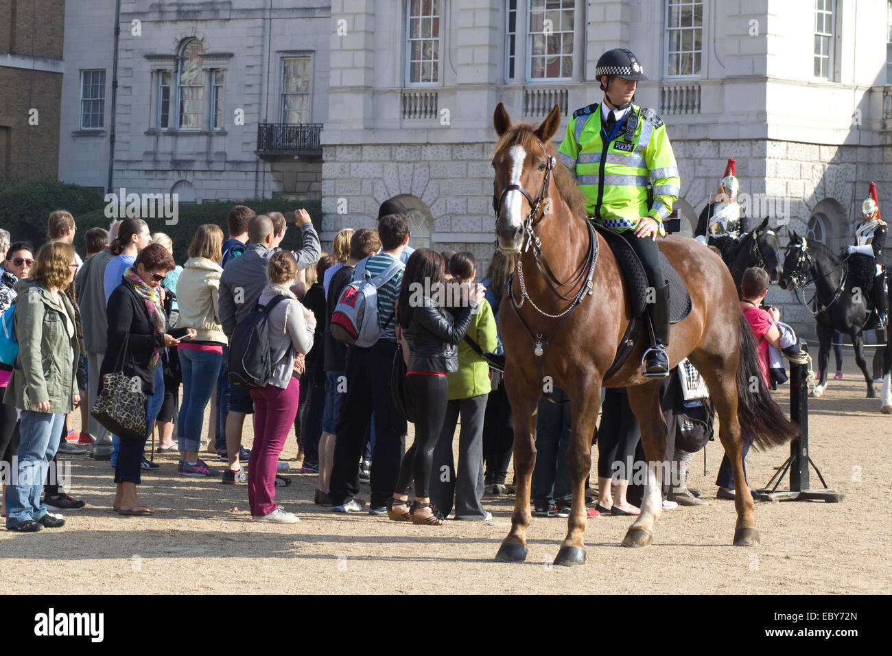 Mounted Police Officer walking in front of Horse guards London Stock Photo
