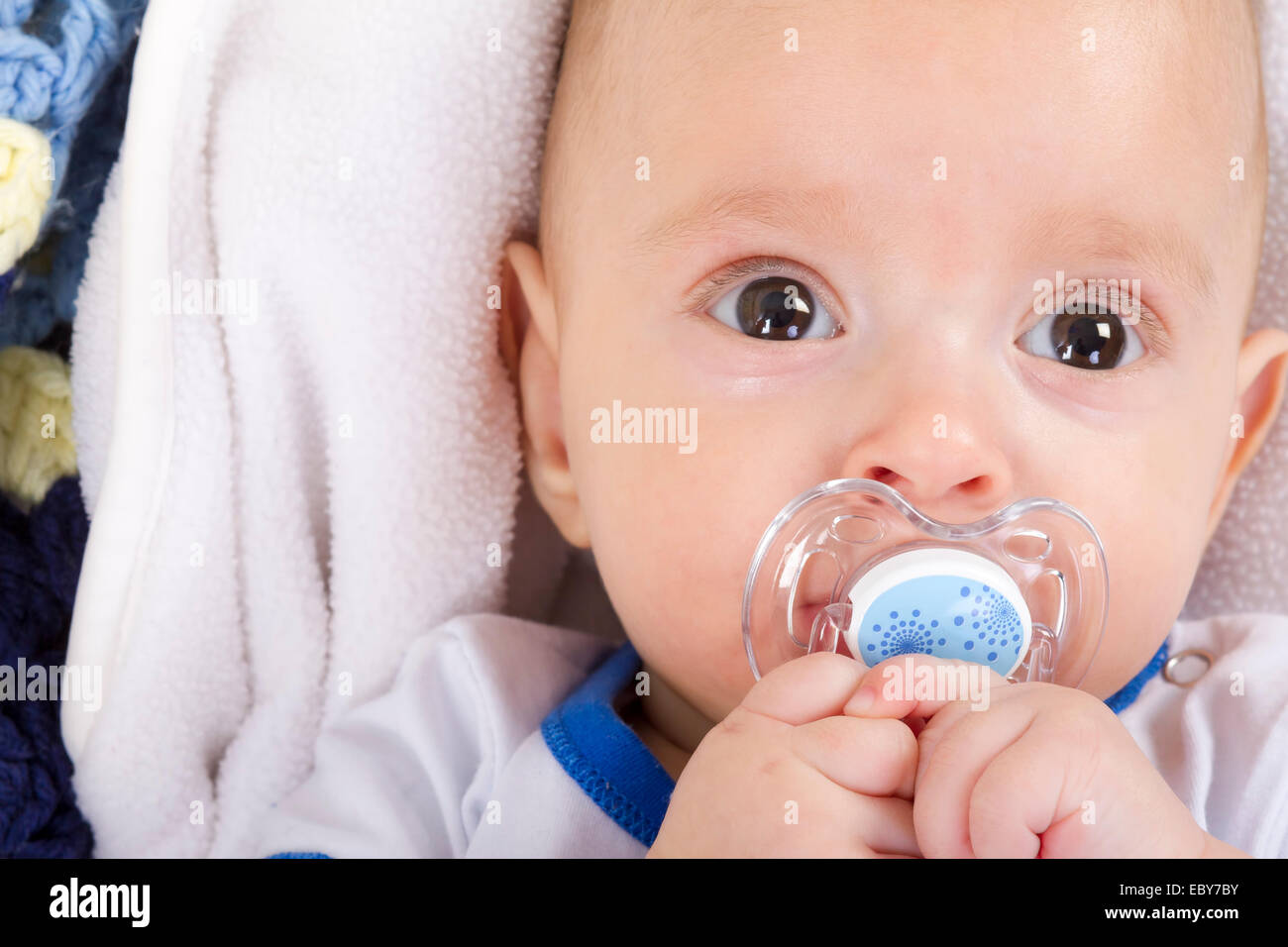 Cute baby with a nipple looking at camera Stock Photo