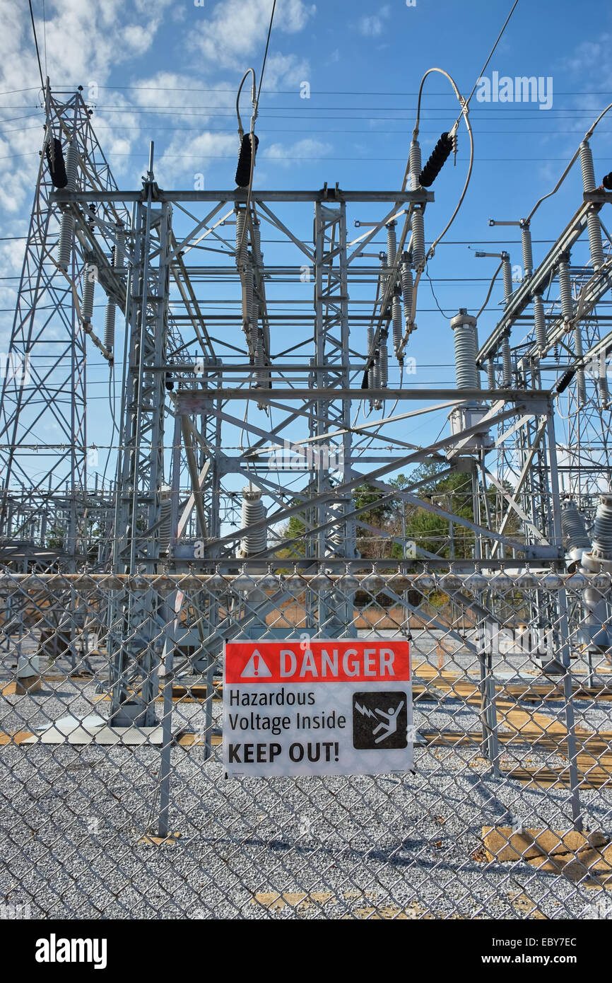 Danger sign warning of hazardous high voltage power lines and advising to keep out at electricity power transfer station, Alabama USA. Stock Photo