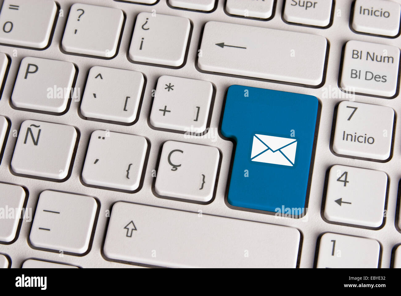 Spanish keyboard with email concept mail envelope icon over blue background button. Image with clipping path for easy change the Stock Photo