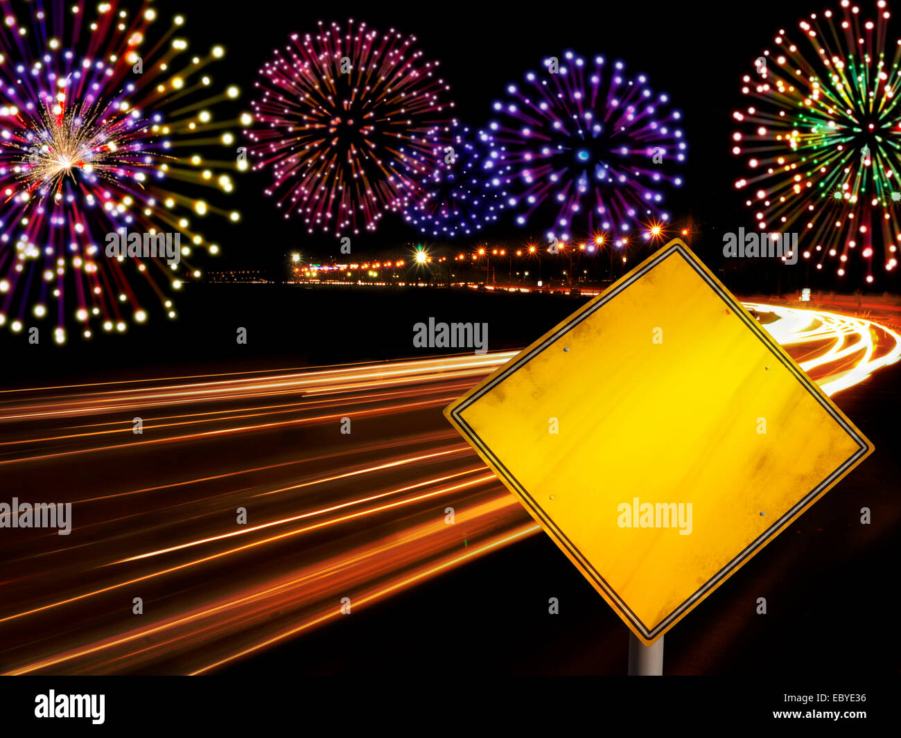 Happy New Year fireworks and city cars highway lights with copy space in yellow road sign. Stock Photo
