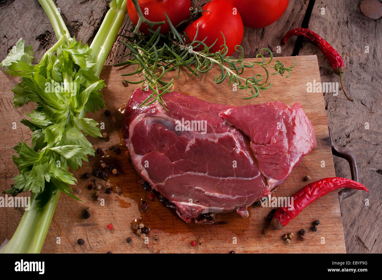 a beef steak on a wooden cutting board ready for the barbecue Stock Photo