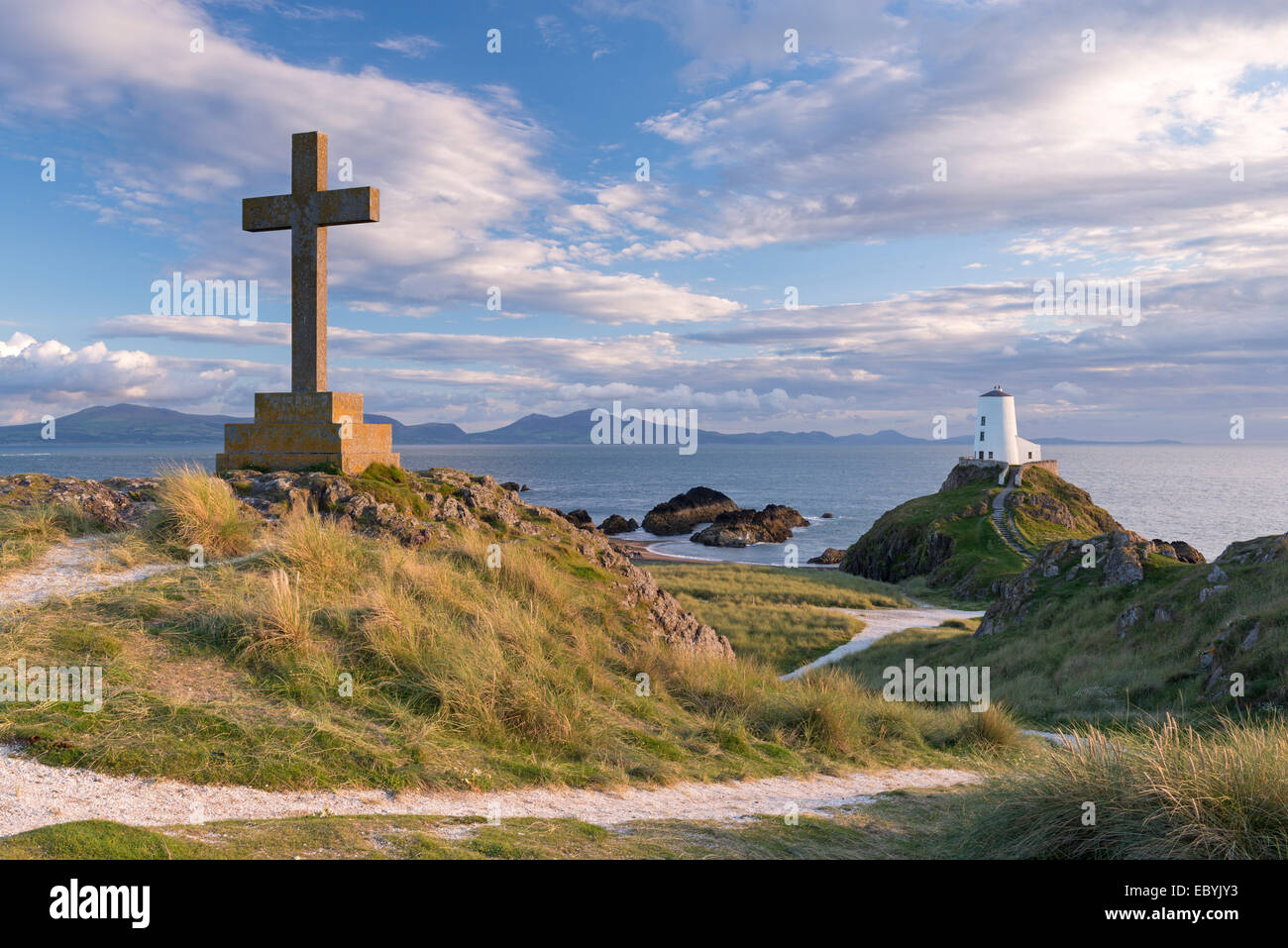 Cross and lighthouse on Llanddwyn Island, Anglesey, Wales. Autumn (September) 2013. Stock Photo