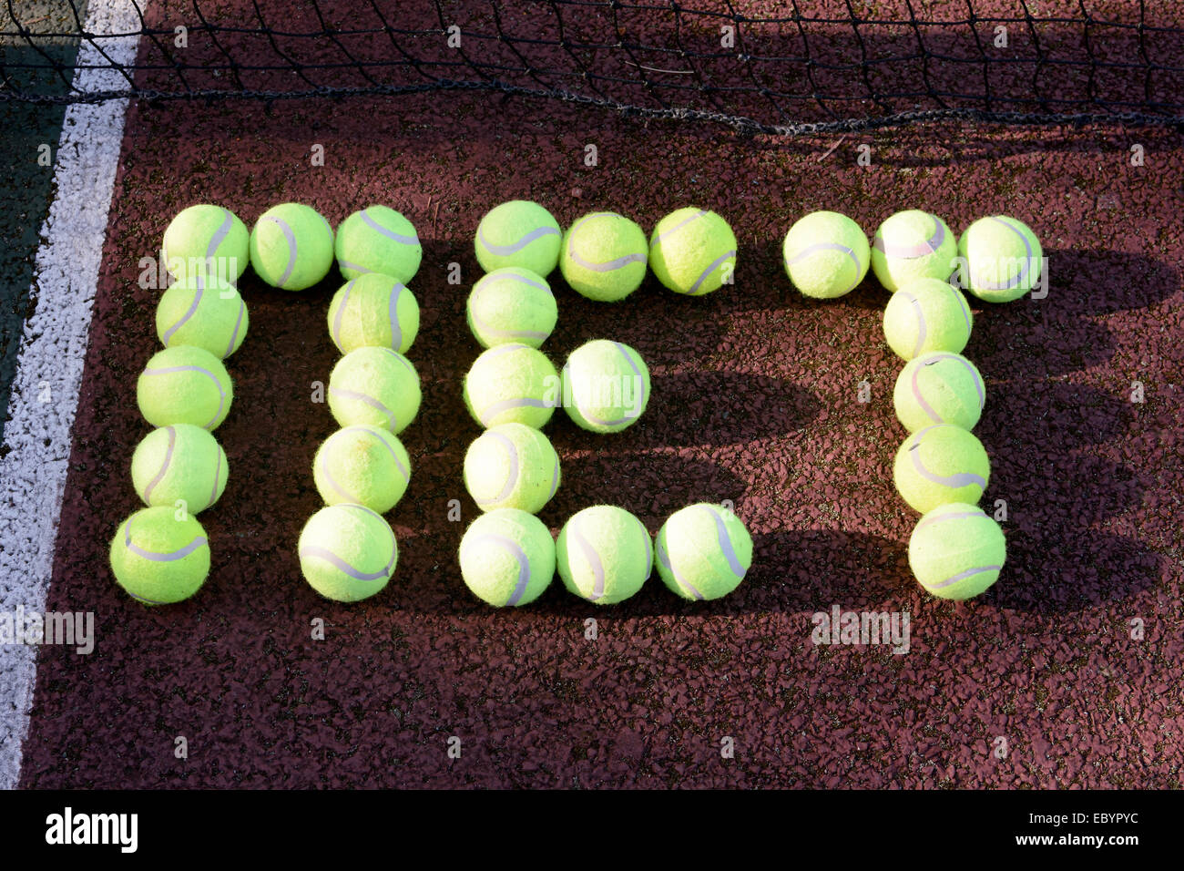 Tennis net made from tennis balls on hard court Stock Photo