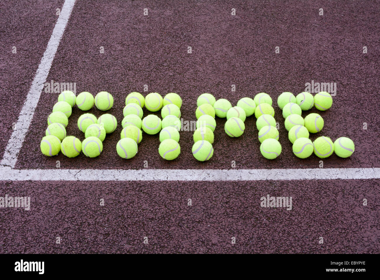 Tennis game made from tennis balls on hard court Stock Photo