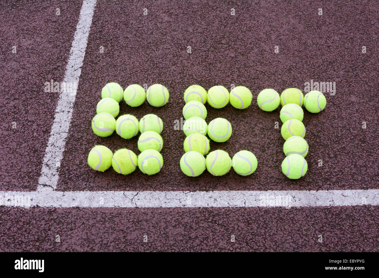 Tennis set made from tennis balls on hard court Stock Photo