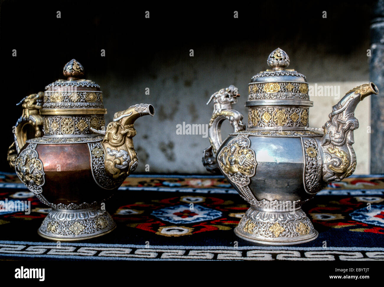 ladakh 2 ceremonial tea pots brass copper gold silver intricate dragons decorative beaten brass rug Stock Photo
