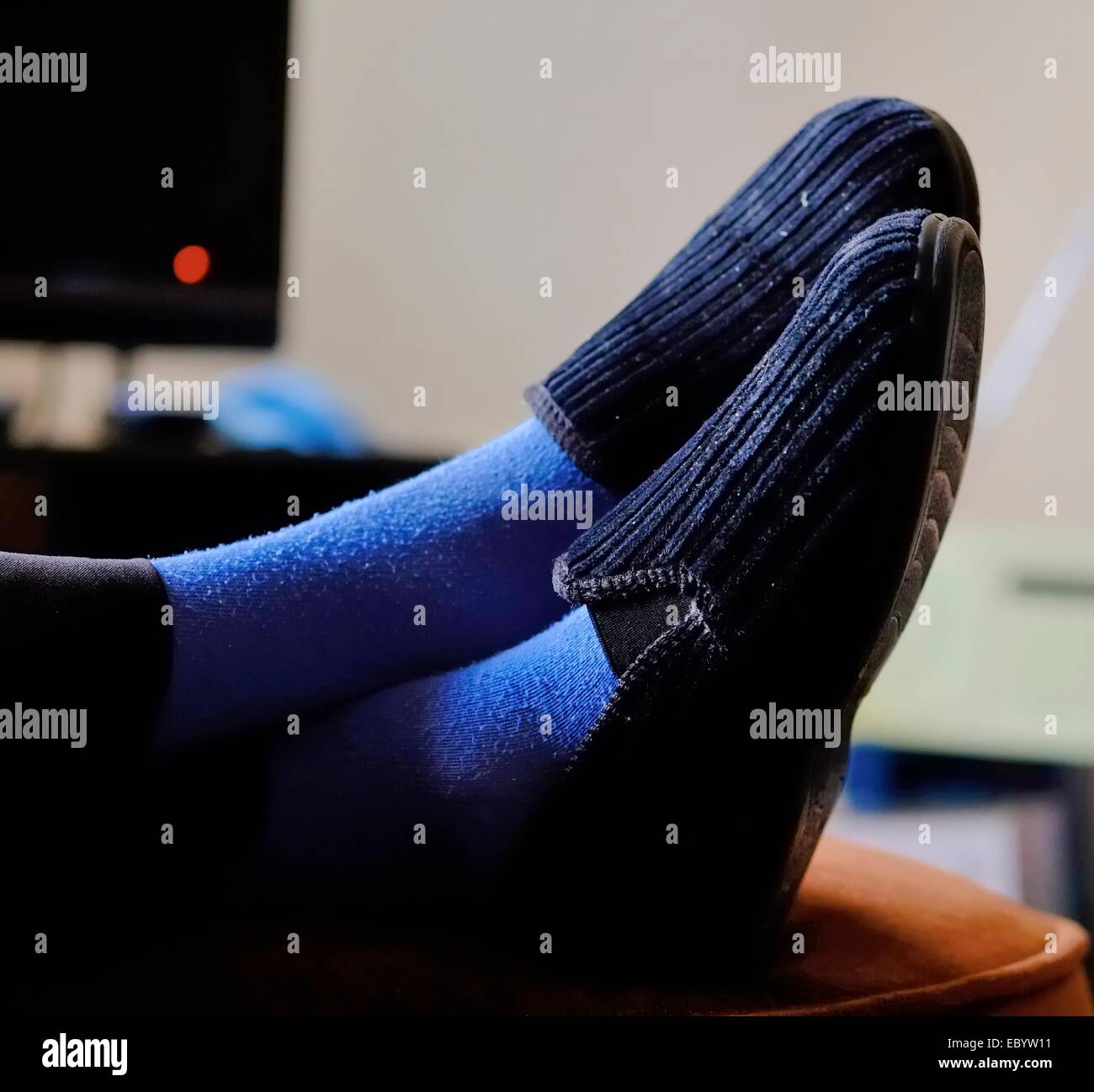 A pensioner relaxing with his feet up wearing slippers England UK Stock Photo