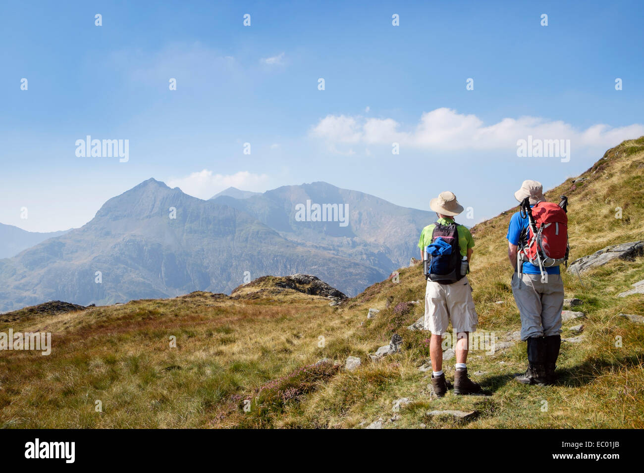 Two hikers looking back at Snowdon horseshoe from Red Route up Glyder Fawr in late summer in mountains of Snowdonia National Park (Eryri) Wales UK Stock Photo