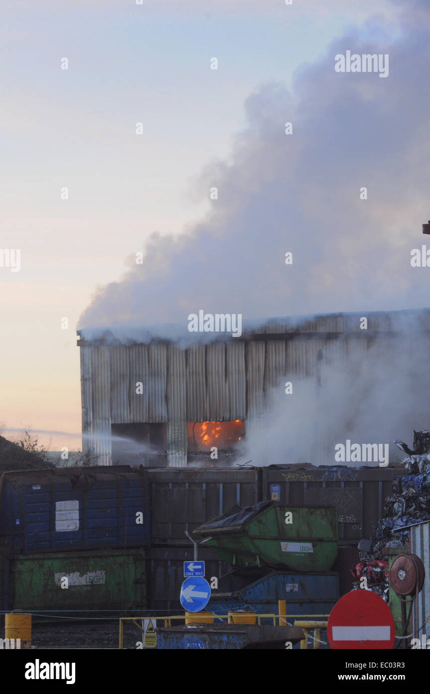 Newhaven, East Sussex, UK.6 December 2014.Fire at Rubbish recycling plant continues to burn at sunset.Fire fighters expect it may burn for some days. Stock Photo