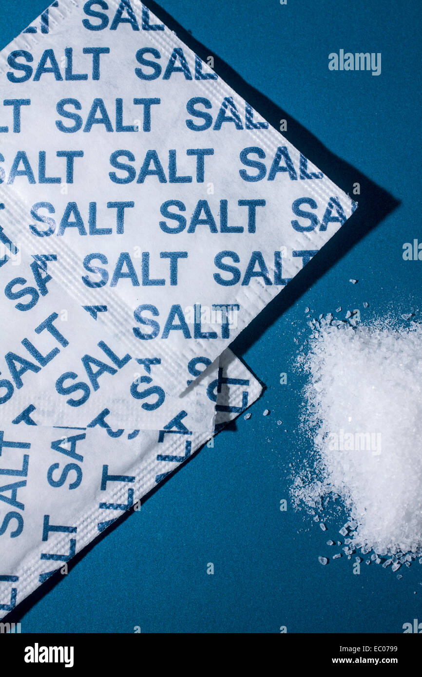Salt sachets on a blue background Stock Photo - Alamy