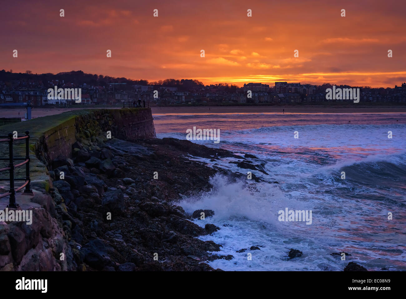 Sunset over the harbour with waves crashing at North Berwick, East Lothian, Scotland. Stock Photo