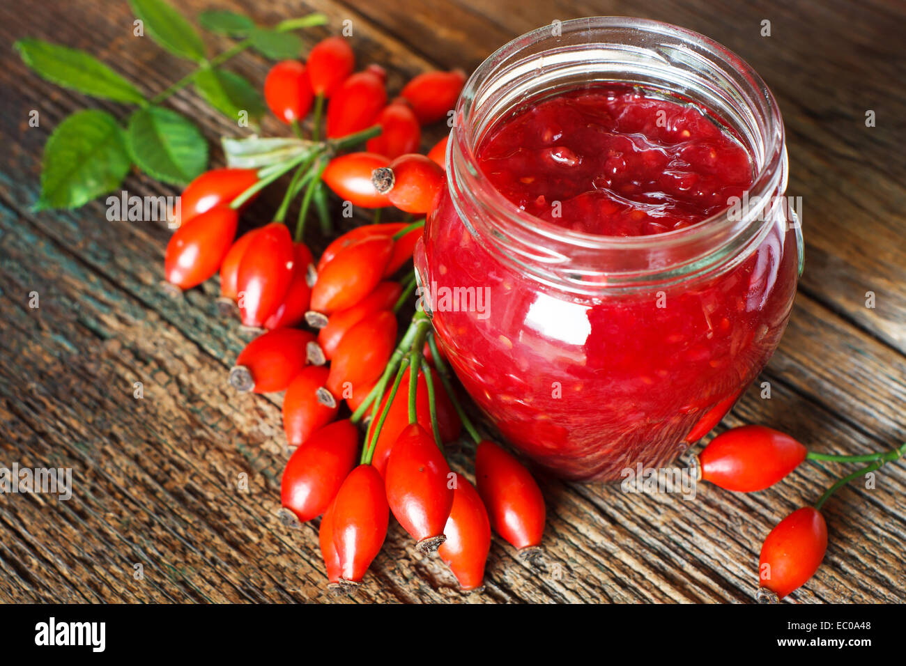 Jam with rose hips on wooden table Stock Photo