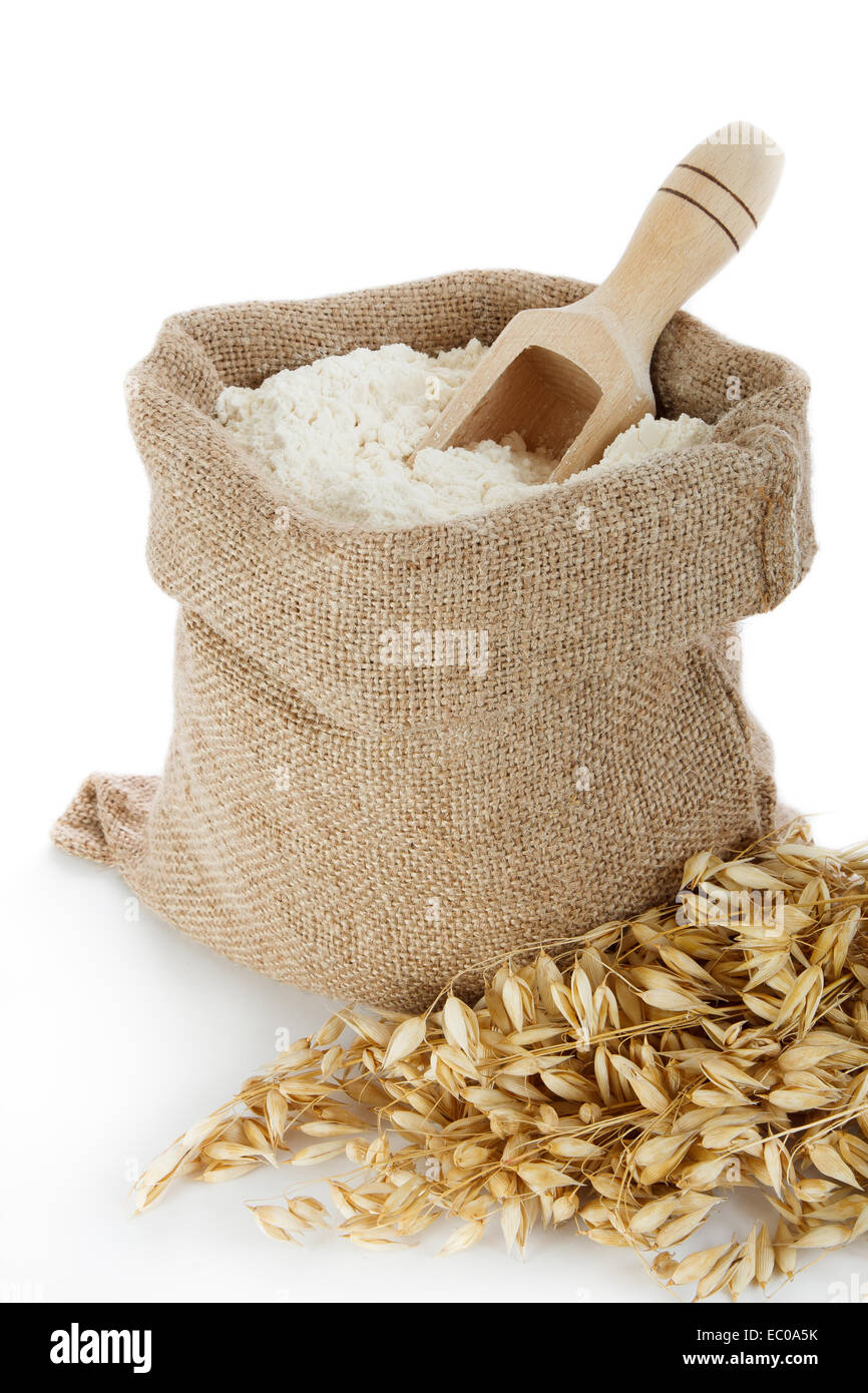 Oat flour in burlap bag on white background Stock Photo