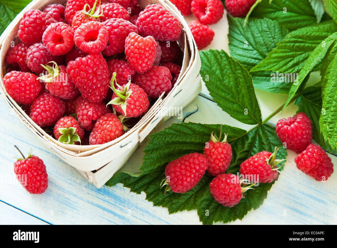 Ripe raspberries in small basket Stock Photo