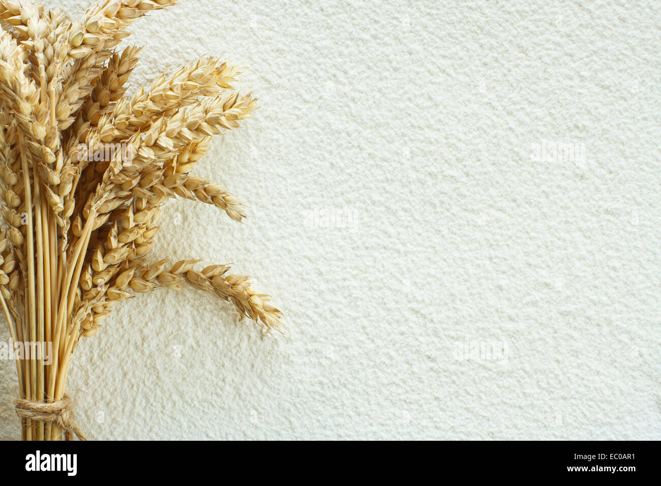 Scattered wheat flour on table as background and wheat spike Stock Photo