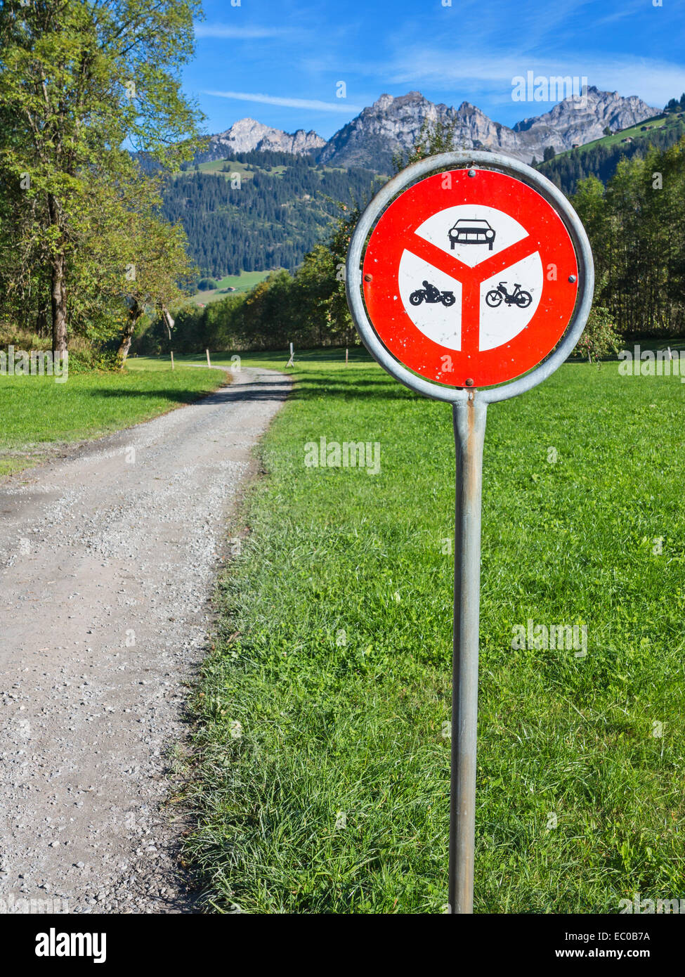 A roadsign on a gravel road running along an alpine valley,  forbidding entry for motorised vehicles Stock Photo