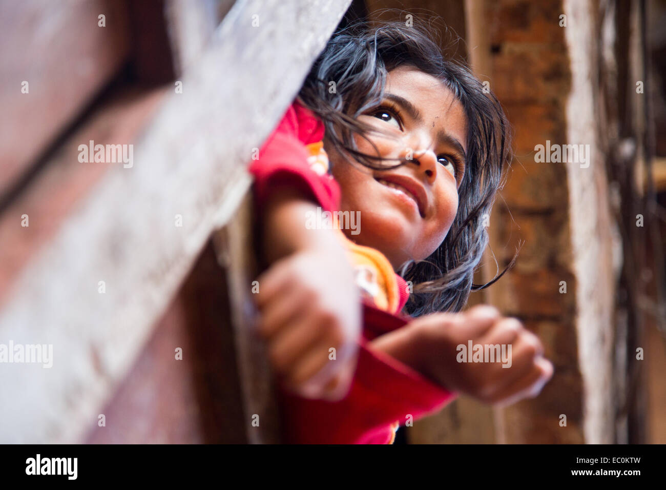 Young Napali girl in a window in Bhaktapur, Nepal Stock Photo