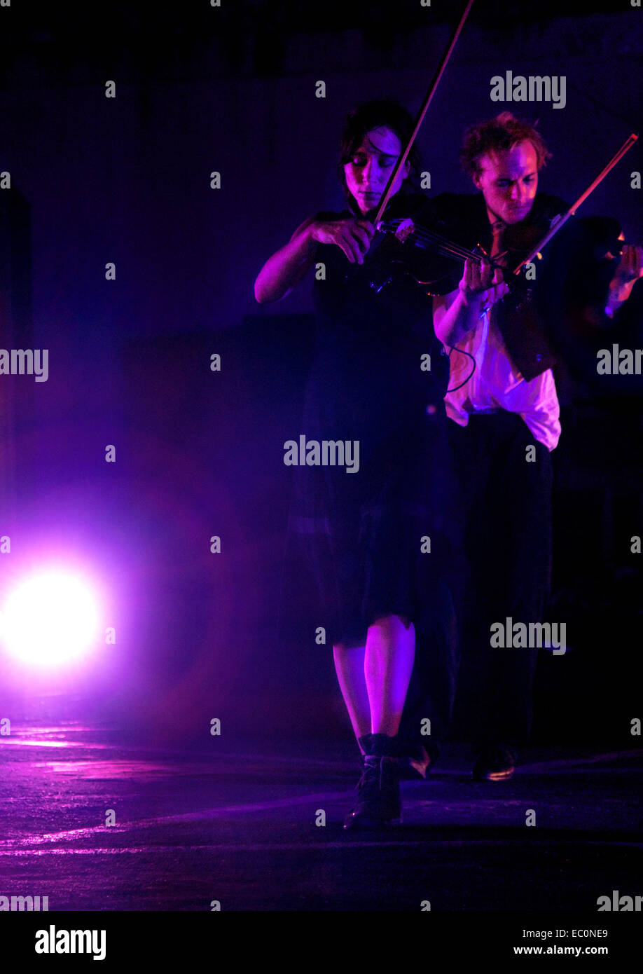 Two violinists in a purple light Stock Photo