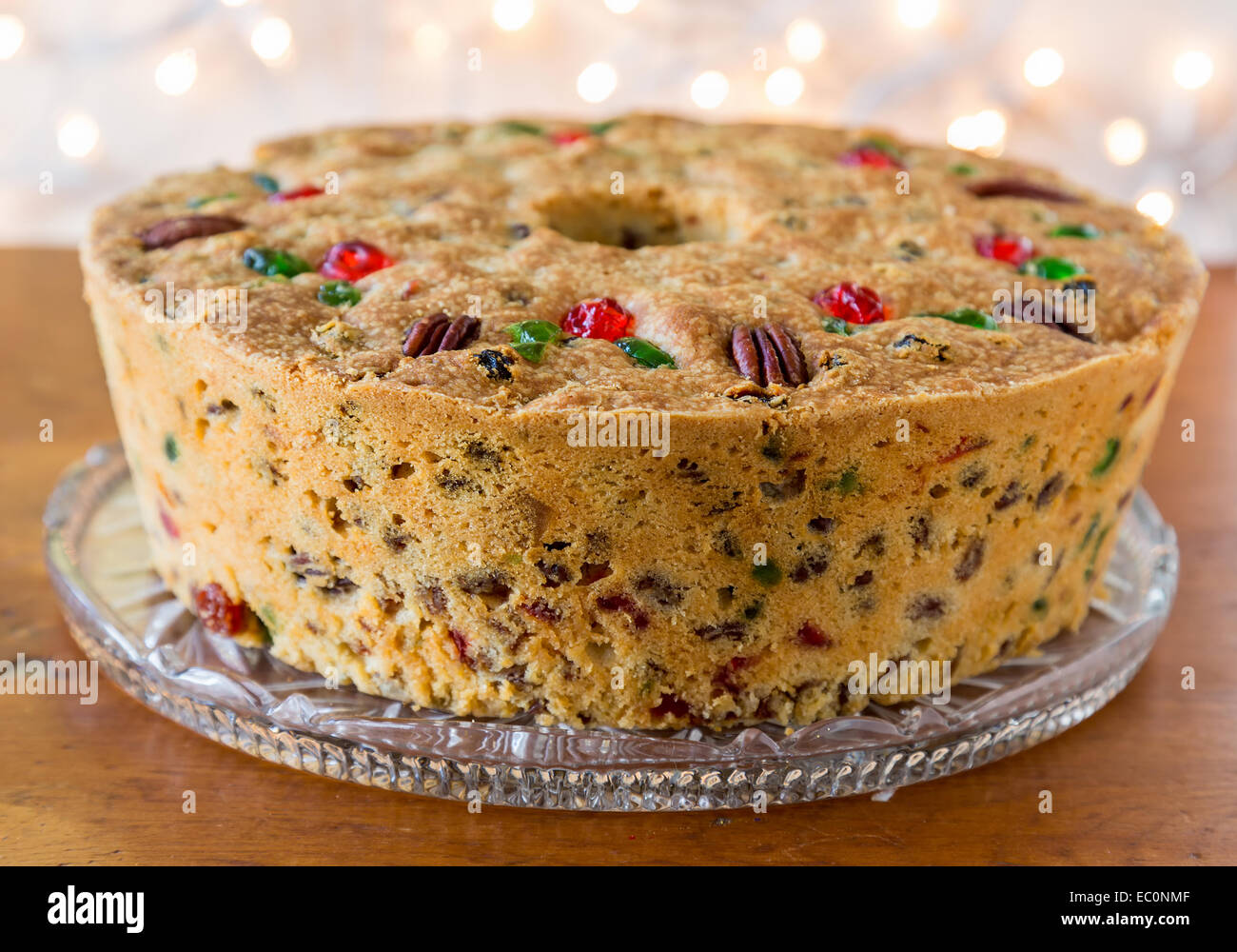 Traditional light fruitcake decorated with pecans and cherries. Stock Photo