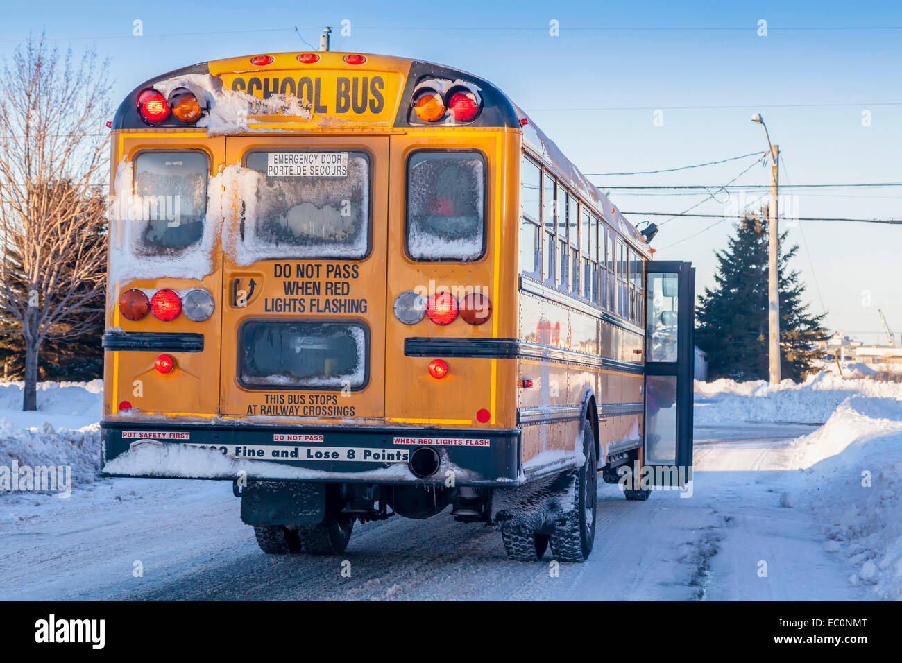 A typical yellow school bus stopped to pick up passengers on an extremely cold winter day. Stock Photo
