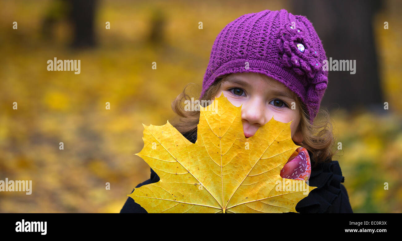 little girl with a maple leaf on the street Stock Photo - Alamy