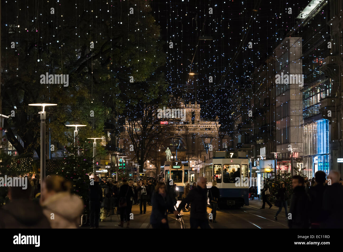 Christmas shoppers and tramway trains on Zurich's crowded Bahnhofstrasse under the glowing Christmas illumination Stock Photo