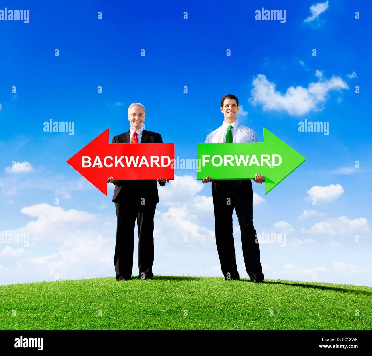 Two Businessmen Holding Contrasting Arrows for Backward and Forward Stock Photo