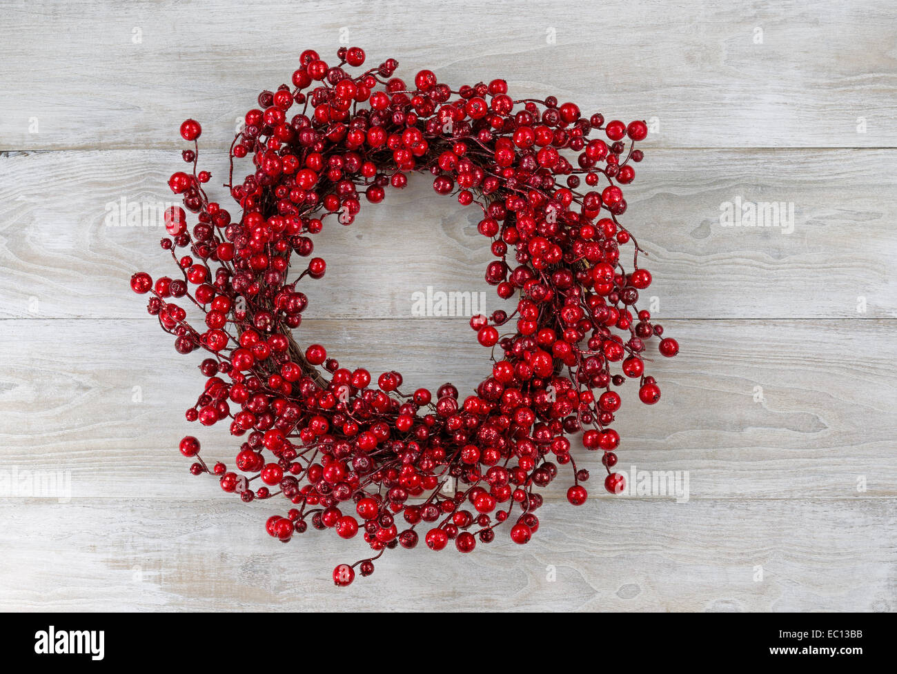Red berry holiday wreath on old white boards Stock Photo