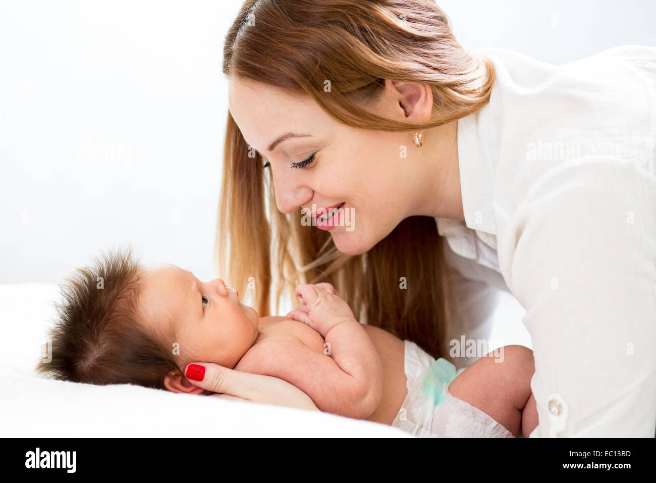 Happy mother cuddling her newborn baby Stock Photo