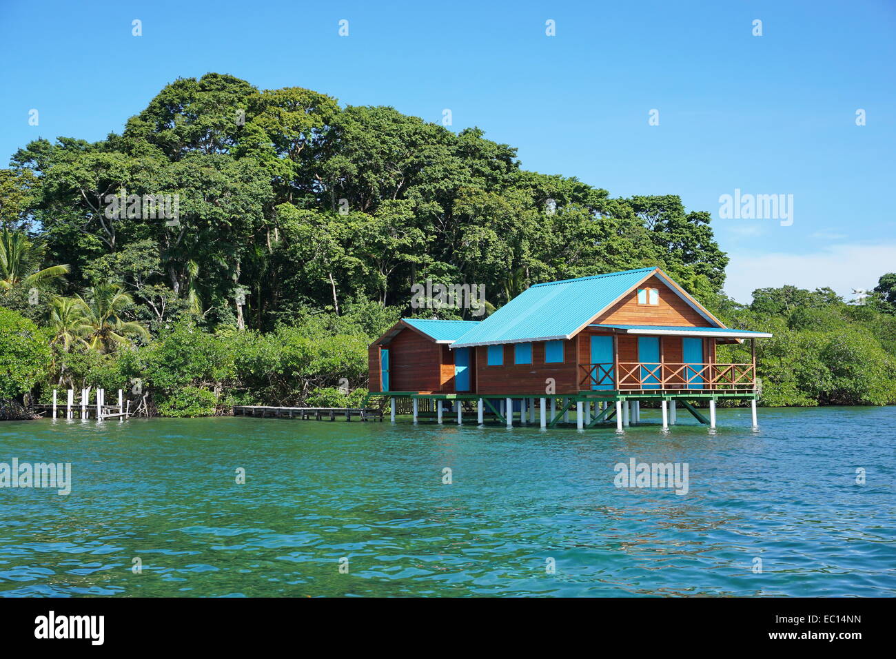 Overwater bungalow with lush tropical vegetation in background, Caribbean, Bocas del Toro, Panama Stock Photo