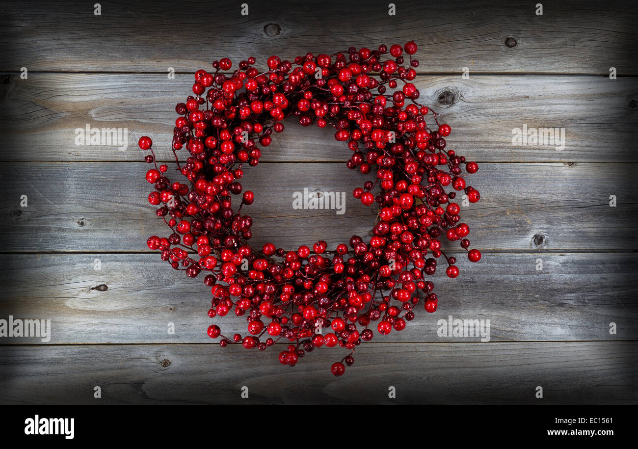 Red berry holiday wreath on rustic wood with vignette border Stock Photo