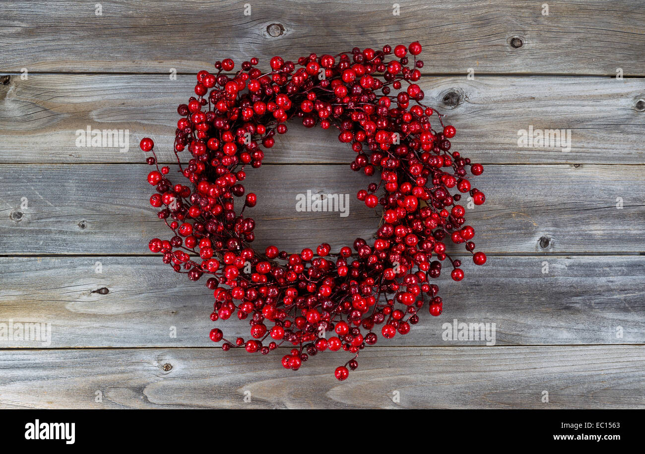 Red berry holiday wreath on rustic wood Stock Photo